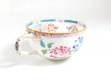 a cup with a handle that has a flower design on it