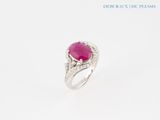 un gros plan d'une bague sertie d'une pierre rose et de diamants