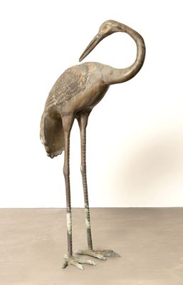 une statue en bronze représentant un oiseau posé sur une table