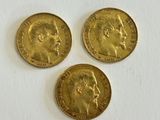 three gold sovereigns, one with the head of a man and one with a woman