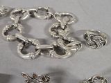 a lot of silver bracelets and rings on a table