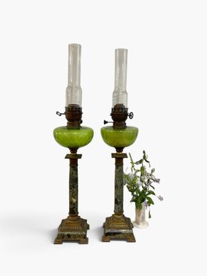 two green glass lamps sitting next to each other on a table