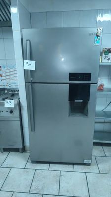 a stainless steel refrigerator in a kitchen with a sink and stove