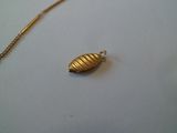 un collier en or sur lequel se trouve un petit objet en or