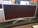 two monitors sitting on a table in front of each other
