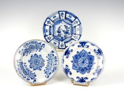 trois assiettes bleues et blanches à motifs sur une surface blanche