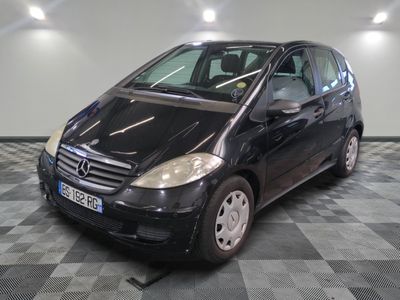 la photo d'une petite voiture noire garée sur un sol en damier