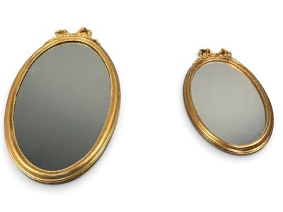 deux miroirs ovales aux cadres dorés sur fond blanc