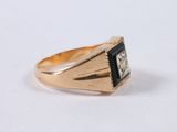 an image of a close up of a gold ring with a black stone