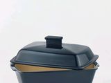 a black casserole dish with a lid on a white background