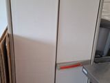 two refrigerators sitting next to each other in a room