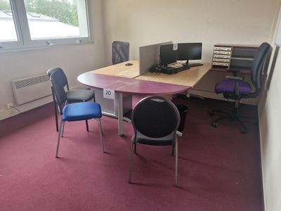une pièce équipée d'un bureau, de chaises et d'un ordinateur posé dessus