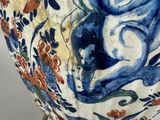 a blue and white vase sitting on a gold stand