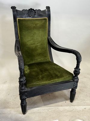 une chaise ancienne noire et verte, dont l'assise est recouverte de velours vert