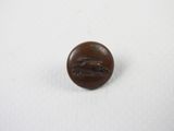 un gros plan d'un bouton marron sur une surface blanche
