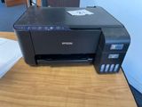 epson printer on a desk with paper on it