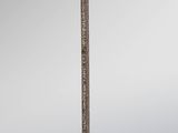 a close up of a sword with a red handle on a gray background