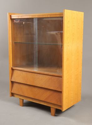 une vitrine en bois avec des portes vitrées et des tiroirs