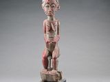 une statue en bois d'un homme avec un chapeau sur la tête