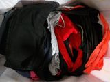 une pile de vêtements posée sur un lit