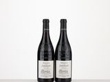 two bottles of wine sitting on top of a table next to each other