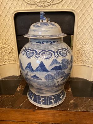 a large blue and white vase sitting on a table