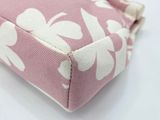 a pink purse with white flowers on it and a gold chain