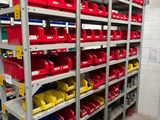 many shelves with red and yellow bins on them