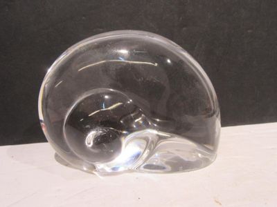 a clear glass object on a table with a black background