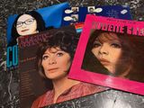 three records on a table with a woman ' s face on them