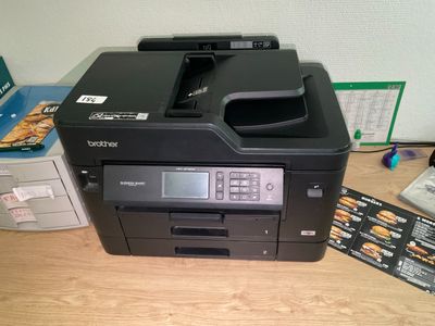 une imprimante posée sur une table à côté d'autres objets