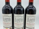 trois bouteilles de vin posées sur une table blanche