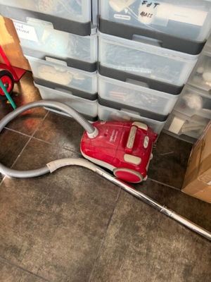 un aspirateur posé par terre à côté d'une pile de cartons