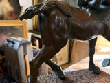 bronze statue of a man on a horse in a room full of pictures