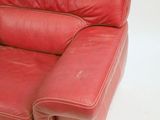 a red leather couch sitting on a white surface