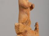 statue of a bear on a rock with a bird in its hand