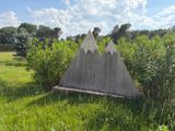 a cement triangle in the middle of a grassy field