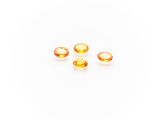 a group of three yellow sapphires on a white surface