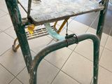 a small table with a metal top on a tiled floor