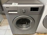 une machine à laver et un sèche-linge posés sur un sol carrelé