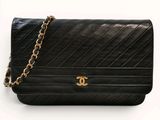 un gros plan d'un sac à main noir entouré d'une chaîne