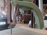 a machine that is cutting a piece of wood in a workshop