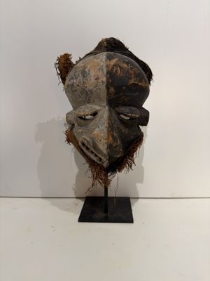an image of a wooden mask on a stand on a white surface