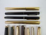several different types of fountain pens lined up on a white surface