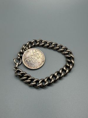 un bracelet à chaîne en argent orné d'une pièce
