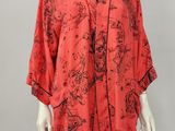 a woman ' s red robe with black and white flowers on it