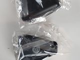 two black remotes wrapped in plastic bags on a table