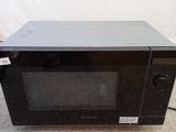 a black microwave oven sitting on the floor in a room
