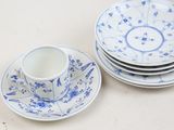 a stack of blue and white plates and a cup and saucer