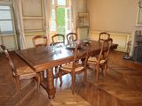 a wooden table and chairs in a room with a fireplace
